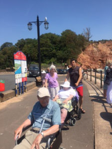 Residents and staff walking along Sidmouth beach