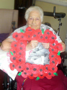 Resident with their homemade poppy memorial wreath