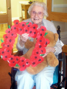 Resident with their homemade poppy memorial wreath