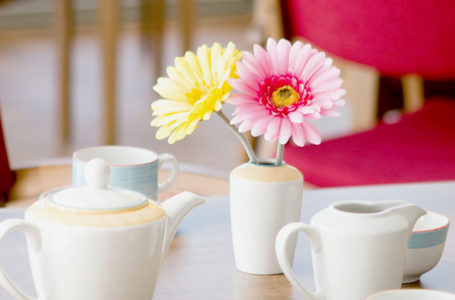 Close up image of tea set and faux flowers in Notaro care home dining room