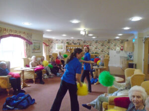 Residents, relatives and staff with giant coloured pom poms