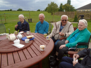 Residents and relatives enjoying afternoon tea in the garden