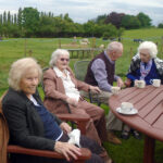 Residents and relatives enjoying afternoon tea in the garden