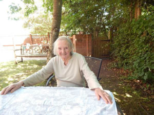 Resident sat in the garden smiling for the camere