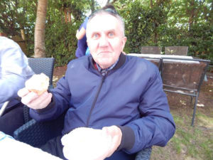 Resident sat in the garden enjoying a cupcake