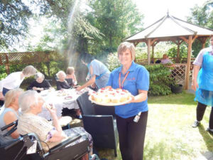 Activities coordinator with a tray of homemade scones