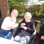 Resident and relative in the garden enjoying their scones