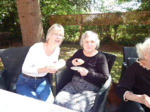 Resident and relative in the garden enjoying their scones