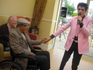 Emilio Santoro-Elvis impersonator singing to resident