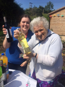 Activities Coordinator, Louise with resident's loved one holding their raffle prizes
