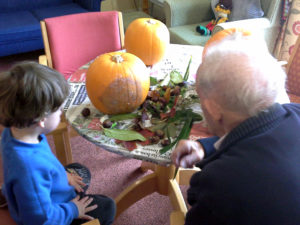 residents and Little Pips children decorating pumpkins