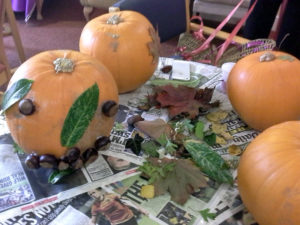 Pumpkins decorated with autumn leaves and conkers
