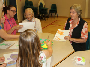 Resident, Pam showing her art work to the children