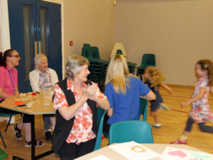 Everyone clapping and cheering the girls whilst they race in the hall