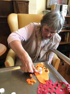 Cedar Lodge resident cutting shapes out of icing