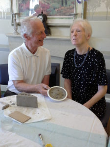 relative and resident presenting her finished cake made out of clay