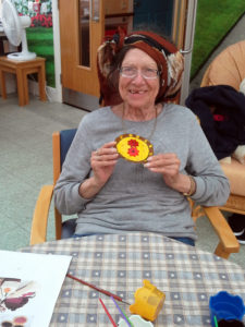 resident with her finished painted clay cake