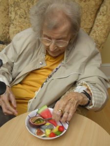 Clarence Park resident tasting and choosing what fruits to have in their cake