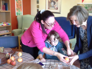 Little pips children and residents decorating apples in chocolate