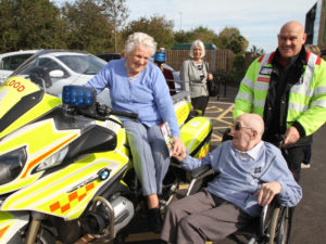 Gwen sat on the motorbike holding hands with her husband, John ( Casa di Lusso resident)