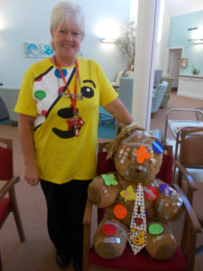Activities coordinator wearing her Pudsey Bear tshirt with their teddy bear