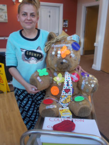 La Fontana staff member in her pajamas with their teddy bear
