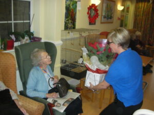 Resident receiving a poinsettia plant
