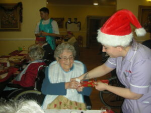Resident pulling a cracker with staff member