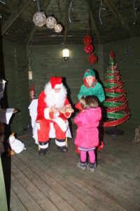 Father Christmas and his Elf giving out presents the children at the Limes Christmas Party