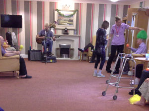 Staff and residents having fun on National Smile Day with Chris Clarke's live music