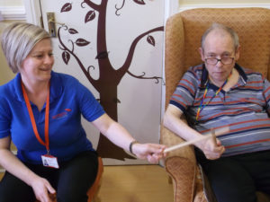 Pauline, Activities coordinator, making music with drumsticks with a resident
