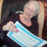 Casa di Lusso resident showing off her sign language course completion certificate