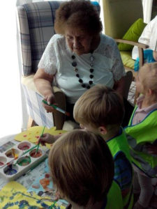 Resident and children painting butterfly pictures