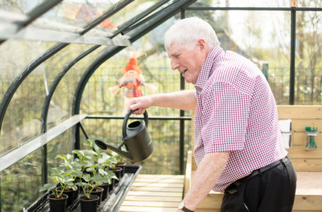 Resident watering the plants in the green house at Casa di Lusso care home Bridgwater